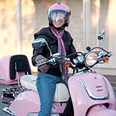 Woman riding pink scooter. 