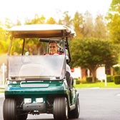 Man driving a golf cart on the street. 