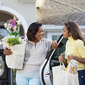 Mom and daughter unloading groceries from car.