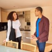 Woman and man looking at apartment while landlord looks at paperwork.  