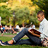 Student reading under a tree.