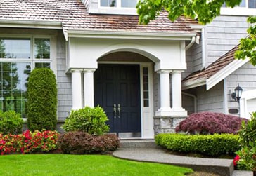 House with gray siding and navy front door. 