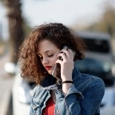 A woman is making a call on a cellphone.