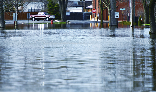 A flooded street in front of homes.