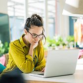 Woman sitting at desk on a computer. 
